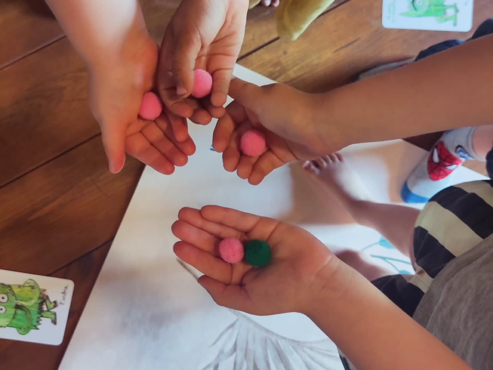 Un temps sensoriel : des enfants tiennent des pompons colorés dans leurs mains